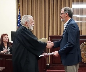A judge shakes hands with a school board member.